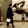 MILAN, ITALY - DECEMBER 19:  People walking in the underground pass a poster featuring David Beckham modeling underwear in the latest Emporio Armani campaign on December 19, 2008 in Milan, Italy. It is anticipated that Victoria Beckham will accompany husb