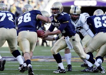 BALTIMORE - DECEMBER 01:  Kaipo-Noa Kaheaku-Enhada #10 of the Navy Midshipmen hands the ball to Eric Kettani #36 against the Army Black Knights during the 108th Army v Navy football game on December 1, 2007 at M&T Bank Stadium in Baltimore, Maryland.  (Ph
