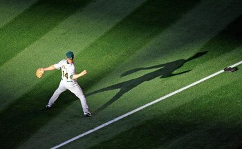 ANAHEIM, CA - APRIL 06:  Mark Ellis #14 of the Oakland Athletics throws the ball during pre game warm up against Los Angeles Angels of Anaheim on opening day at the Angel Stadium of Anaheim on April 6, 2009 in Anaheim, California.  (Photo by Kevork Djanse