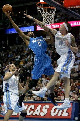 DENVER - JANUARY 17:  Rashard Lewis #9 of the Orlando Magic lays up a shot over the defense of Chris Andersen #11 of the Denver Nuggets during NBA action at the Pepsi Center on January 17, 2009 in Denver, Colorado. NOTE TO USER: User expressly acknowledge
