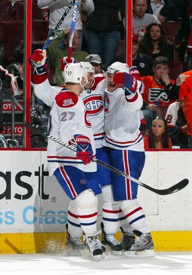 PHILADELPHIA - FEBRUARY 27:  Mathieu Schneider #24 (C) of the Montreal Canadiens is mobbed by teammates Alexei Kovalev #27 and Andrei Markov #79 after scoring the overtime goal against the Philadelphia Flyers on February 27, 2009 at Wachovia Center in Phi