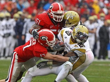 ATHENS, GA - NOVEMBER 29:  Defensive teammates Chad Gloer #17 and Akeem Dent #51 of the Georgia Bulldogs tackle running back Roddy Jones #20 of the Georgia Tech Yellow Jackets while Jones' teammate Marcus Wright #3 tries to block during the game at Sanfor