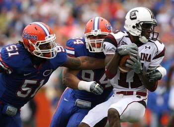 GAINESVILLE, FL - NOVEMBER 15:  Linebacker Brandon Spikes #51 and defensive end Justin Trattou #94 of the Florida Gators bring down wide receiver Kenny McKinley #11 of the South Carolina Gamecocks at Ben Hill Griffin Stadium on November 15, 2008 in Gaines