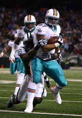 EAST RUTHERFORD, NJ - DECEMBER 28:  Phillip Merling #97 of The Miami Dolphins rumbles in for a touchdown after making an interception thrown by Brett Favre of The New York Jets during their game on December 28, 2008 at Giants Stadium in East Rutherford, N