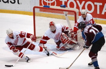 DETROIT, MI - MAY 27:  Peter Forsberg #21 of the Colorado Avalanche has Dominik Hasek #39, Steve Yzerman #19 and Chris Chelois #24 all down but not out, as Hasek made the save during the last seconds of game five of the Western Conference finals in the St