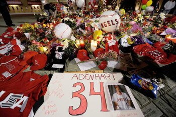ANAHEIM, CA - APRIL 10:  Fans gather around a makeshift memorial to Los Angeles Angels pitcher Nick Adenhart outside Angel Stadium, after the game against the Boston Red Sox on April 10, 2009 in Anaheim, California. Adenhart and two others were killed in 