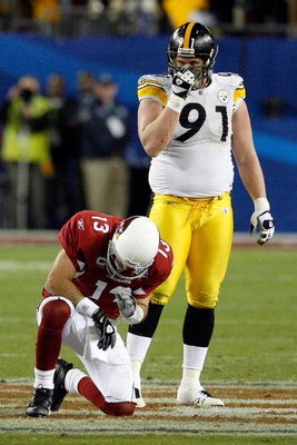 TAMPA, FL - FEBRUARY 01:  Quarterback #13 of the Arizona Cardinals kneels on the field after he was hit on a play in the fourth quarter as Aaron Smith #91 of the Pittsburgh Steelers looks on during Super Bowl XLIII on February 1, 2009 at Raymond James Sta