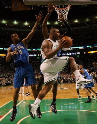 BOSTON - MAY 12:  Glen Davis #11 of the Boston Celtics passes the ball as Rashard Lewis #9 and Dwight Howard #12 of the Orlando Magic defend in Game Five of the Eastern Conference Semifinals during the 2009 NBA Playoffs at TD Banknorth Garden May 12, 2009