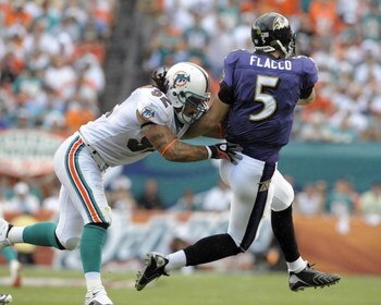 MIAMI, FL - JANUARY 4:  Linebacker Channing Crowder #52 of the Miami Dolphins hits quarterback Joe Flacco #5 of the Baltimore Ravens in an AFC wild card game at Dolphins Stadium January 4, 2009 in Miami, Floirda.  (Photo by Al Messerschmidt/Getty Images)