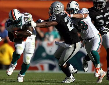 MIAMI - NOVEMBER 16:  Running back Ricky Williams #34 of the Miami Dolphins runs away from safety Gibril Wilson #28 of the Oakland Raiders in the second quarter at Dolphin Stadium November 16, 2008 in Miami, Florida. Miami defeated Oakland 17-15.  (Photo 