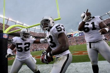 DENVER - SEPTEMBER 16:  Thomas Howard #53 of the Oakland Raiders celebrates his interception for a touchdown with Kirk Morrison #52 and Gerard Warren #61 against the Denver Broncos as the Broncos defeated the Raiders 23-20 in overtime during week two NFL 