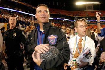 MIAMI - JANUARY 08:  Head coach Urban Meyer of the Florida Gators walks off with the National Championship trophy after their 24-14 win against the Oklahoma Sooners during the FedEx BCS National Championship game at Dolphin Stadium on January 8, 2009 in M