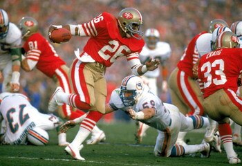 STANFORD, CA - JANUARY 20:  Wendell Tyler #26 of the San Francisco 49ers works to escape a tackle during Super Bowl XIX against the Miami Dolphins at Stanford Stadium on January 20, 1985 in Stanford, California.  The 49ers defeated the Dolphins 38 to16. (