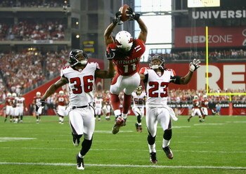 GLENDALE, AZ - JANUARY 03:  Wide receiver Larry Fitzgerald #11 of the Arizona Cardinals makes a leaping 42 yard touchdown reception over Lawyer Milloy #36 and Chris Houston #23 of the Atlanta Falcons during the first quarter of the NFC Wild Card Game on J