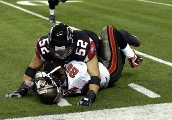 ATLANTA - DECEMBER 14: Linebacker Coy Wire #52 of the Atlanta Falcons knocks the helmet off of running back Warrick Dunn #28 of the Tampa Bay Buccaneers at the Georgia Dome on December 14, 2008 in Atlanta, Georgia.  (Photo by Al Messerschmidt/Getty Images