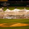 ST LOUIS - OCTOBER 26:  Rain falls as the grounds crew remove the tarps from the infield before the start of game three of the World Series between the Boston Red Sox and the St. Louis Cardinals during on October 26, 2004 at Busch Stadium in St. Louis, Mi