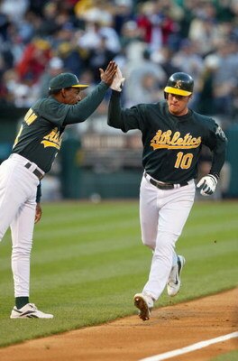 OAKLAND, CA - MAY 5:  Third base coach Ron Washington #10 of the Oakland Athletics high fives infielder Scott Hatteberg #10 after Hatterberg hit a home run against the New York Yankees during the game at Network Associates Coliseum on May 5, 2004 in Oakla