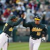 OAKLAND, CA - MAY 5:  Third base coach Ron Washington #10 of the Oakland Athletics high fives infielder Scott Hatteberg #10 after Hatterberg hit a home run against the New York Yankees during the game at Network Associates Coliseum on May 5, 2004 in Oakla