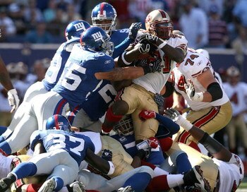 EAST RUTHERFORD, NJ - OCTOBER 21:  Frank Gore #21 of the San Francisco 49ers is tackled by the New York Giants on October 21, 2007 at Giants Stadium in East Rutherford, New Jersey.  (Photo by Nick Laham/Getty Images)