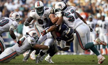 SAN DIEGO - DECEMBER 11:  Running back LaDainian Tomlinson #21 of the San Diego Chargers is tackeld by Zach Thomas #54 and Channing Crowder #52 of the Miami Dolphins during the Chargers 23-21 loss to the Dolphins during the 2nd half of their NFL Game on D