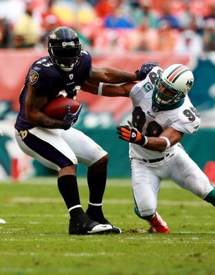 MIAMI - DECEMBER 16:  Defensive end Jason Taylor #99 of the Miami Dolphins stops running back Willis McGahee #23 of the Baltimore Ravens at Dolphin Stadium December 16, 2007 in Miami, Florida. The Dolphins defeated the Ravens 22-16 for their first victory
