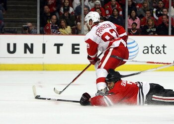 CHICAGO - MAY 24:  Johan Franzen #93 of the Detroit Red Wings skates with the puck as Brent Seabrook #7 the Chicago Blackhawks slides head first down the ice behind him during Game Four of the Western Conference Championship Round of the 2009 Stanley Cup 