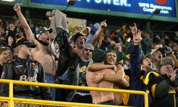 GREEN BAY, WI - DECEMBER 28: Fans of the Green Bay Packers celebrate after hearing the Minnesota Vikings were defeated by the Arizona Cardinals making the Packers the NFC North Division champions during a game against the Denver Broncos December 28, 2003 