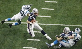 HOUSTON, TX - FEBRUARY 1:  Quarterback Tom Brady #12 of the New England Patriots is caught by safety Mike Minter #30 of the Carolina Panthers in the second quarter during Super Bowl XXXVIII at Reliant Stadium on February 1, 2004 in Houston, Texas. (Photo 