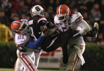 COLUMBIA, SC - NOVEMBER 10:  Moe Brown, #9 of the South Carolina Gamecocks is tackled by Major Wright, #21 and Brandon Spikes, #51 of the Florida Gators at the Williams-Brice Stadium on November 10, 2007 in Columbia, South Carolina.  (Photo by Scott Halle
