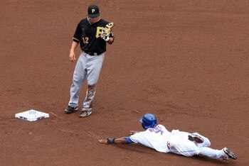 NEW YORK - MAY 09:  Freddy Sanchez #12 of the Pittsburgh Pirates watches Jose Reyes #7 of the New York Mets dive into second base in the first inning on May 9, 2009 at Citi Field in the Flushing neighborhood of the Queens borough of New York City. Reyes a