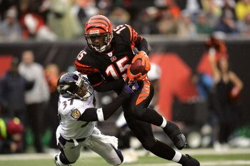 CINCINNATI - NOVEMBER 27:  Wide receiver Chris Henry #15 of the Cincinnati Bengals evades cornerback Deion Sanders #37 of the Baltimore Ravens during the game on November 27, 2005 at Paul Brown Stadium in Cincinnati, Ohio. Cincinnati won the game, 42-29. 