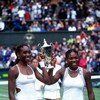 10 Jul 2000:  Venus Williams (left) of the USA and her sister and doubles partner Serena raise the trophy after they claimed victory in the womens doubles final during the Wimbledon Lawn Tennis Championship at the All England Lawn Tennis and Croquet Club,