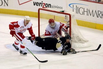 PITTSBURGH - JUNE 9:  Sidney Crosby #87 of the Pittsburgh Penguins is tripped in front of goaltender Chris Osgood #30 of the Detroit Red Wings as Nicklas Lidstrom #5 helps defend during Game Six of the 2009 NHL Stanley Cup Finals at the Mellon Arena on Ju
