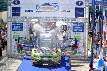 LOUTRAKI, GREECE - JUNE 14:  Mikko Hirvonen of Finland and Jarmo Lehtinen of Finland celebrate victory on the podium after winning the WRC Acropolis Rally of Greece on June 14, 2009 in Loutraki, Greece  (Photo by Massimo Bettiol/Getty Images)