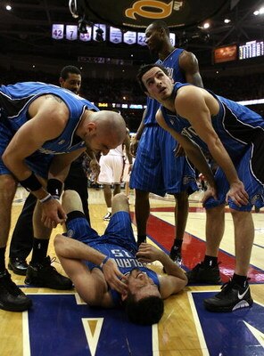 CLEVELAND - MAY 22:  Hedo Turkoglu #15 of the Orlando Magic lays on the court as teammates Marcin Gortat #13 and J.J. Redick # 7 look on against the Cleveland Cavaliers in Game Two of the Eastern Conference Finals during the 2009 Playoffs at Quicken Loans