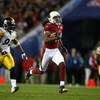 TAMPA, FL - FEBRUARY 01:  Larry Fitzgerald #11 of the Arizona Cardinals runs for yards after the catch on a 64-yard touchdown reception against James Harrison #92 and Bryant McFadden #20 of the Pittsburgh Steelers in the fourth quarter during Super Bowl X