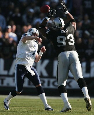 OAKLAND, CA - DECEMBER 19:  Quarterback Billy Volek #7 of the Tennessee Titans throws the ball against pressure from defensive end Tommy Kelly #93 of the Oakland Raiders at Network Associates Coliseum on December 19, 2004 in Oakland, California. (Photo by