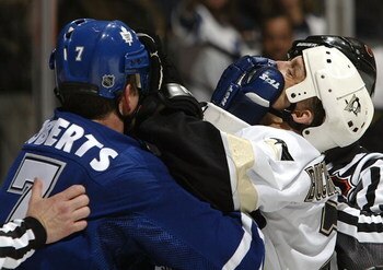 TORONTO - MARCH 11:  Gary Roberts #7 of the Toronto Maple Leafs trades gloves in the face with Kelly Buchberger #7 of the Pittsburgh Penguins March 11, 2004 at Air Canada Centre in Toronto, Ontario, Canada. The Penguins beat the Leafs 3-2.  (Photo By Dave