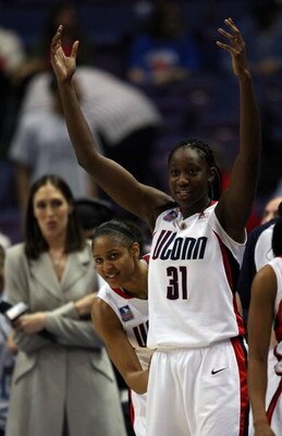 ST. LOUIS - APRIL 05:  Maya Moore #23 of the Connecticut Huskies peeks around a celebrating Tina Charles #31 as former Connecticut player Rebecca Lobo looks on on April 5, 2009 during the Womens Final Four Semifinals at the Scottrade Center on April 5, 20