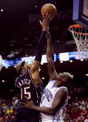 ORLANDO, FL - FEBRUARY 06:  Vince Carter #15 of the New Jersey Nets scores over Adonal Foyle #31 of the Orlando Magic at Amway Arena on February 6, 2008 in Orlando, Florida. NOTE TO USER: User expressly acknowledges and agrees that, by downloading and or 