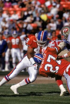 SAN FRANCISCO - AUGUST 3:  Safeties Dennis Smith #49 and Steve Atwater #27 of the Denver Broncos team up for a tackle during pre season game against the San Francisco 49ers at Candlestick Park on August 3, 1992 in San Francisco, California.  The 49ers won