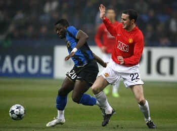 MILAN, ITALY - FEBRUARY 24:  Sulley Muntari of Inter Milan gets past John O'Shea of Manchester United during the UEFA Champions League, Round of Last 16, First Leg match between Inter Milan and Manchester United at the San Siro Stadium on February 24, 200