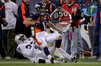 DENVER - NOVEMBER 23:  Cornerback Chris Johnson #37 of the Oakland Raiders tackles Brandon Stokley #14 of the Denver Broncos during week 12 NFL action at Invesco Field at Mile High on November 23, 2008 in Denver, Colorado. The Raiders defeated the Broncos