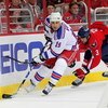 WASHINGTON - APRIL 28: Scott Gomez #19 of the New York Rangers skates the puck past Tom Poti #3   of the Washington Capitals during Game Seven of the Eastern Conference Quarterfinal Round of the 2009 Stanley Cup Playoffs on April 28, 2009 at the Verizon C