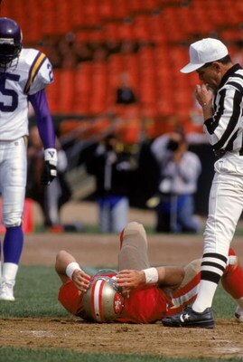 SAN FRANCISCO - OCOTBER 3:  Quarterback Steve Young #8 of the San Francisco 49ers attempts to get up off the field after taking a big hit against the Minnesota Vikings at Candlestick Park on October 3, 1993 in San Francisco, California.  The 49ers won 38-