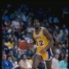 Guard Magic Johnson of the Los Angeles Lakers driibbles the ball down the court during a game at the Great Western Forum in Inglewood, California.