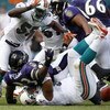 MIAMI - JANUARY 04:  Le'Ron McClain #33 of the Baltimore Ravens fumbles on a first quarter run while being tackled by Paul Soliai #96 and Joey Porter #55 of the Miami Dolphins during their AFC Wild Card playoff game on January 4, 2009 at Dolphin Stadium i