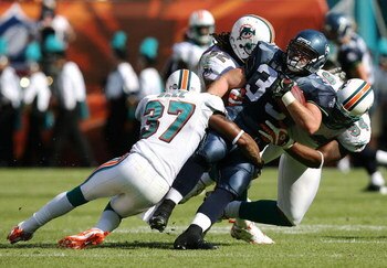 MIAMI - NOVEMBER 09:  Yeremiah Bell #37, Channing Crowder #52 and Randy Starks #94 of the Miami Dolphins bring down fullback Owen Schmitt #35 of the Seattle Seahawks at Dolphin Stadium on November 9, 2008 in Miami, Florida. The Dolphins defeated the Seaha