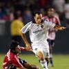 CARSON, CA - AUGUST 14:  Landon Donovan #10 of the Los Angeles Galaxy dribbles the ball past a falling Paulo Nagamura #5 of CD Chivas USA in the second half of their MLS match at the Home Depot Center on August 14, 2008 in Carson, California. The Galaxy a