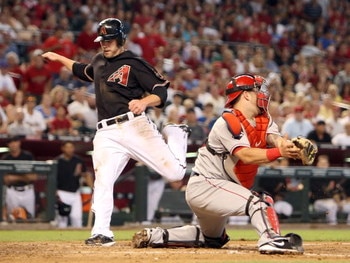 PHOENIX - JUNE 27:  Mark Reynolds #27 of the Arizona Diamondbacks scores a run past catcher Mike Napoli #44 of the Los Angeles Angels of Anaheim during the fourth inning of the major league baseball game at Chase Field on June 27, 2009 in Phoenix, Arizona